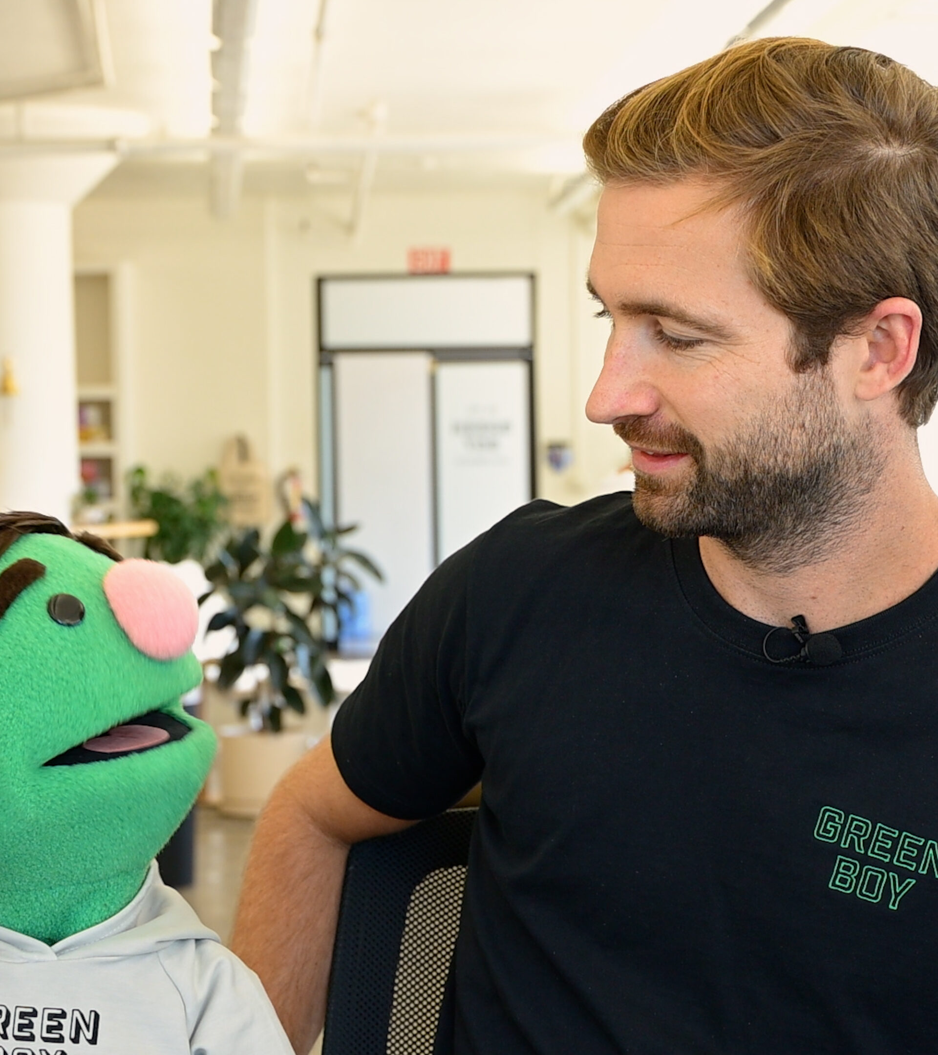 Man Looking at Green Puppet